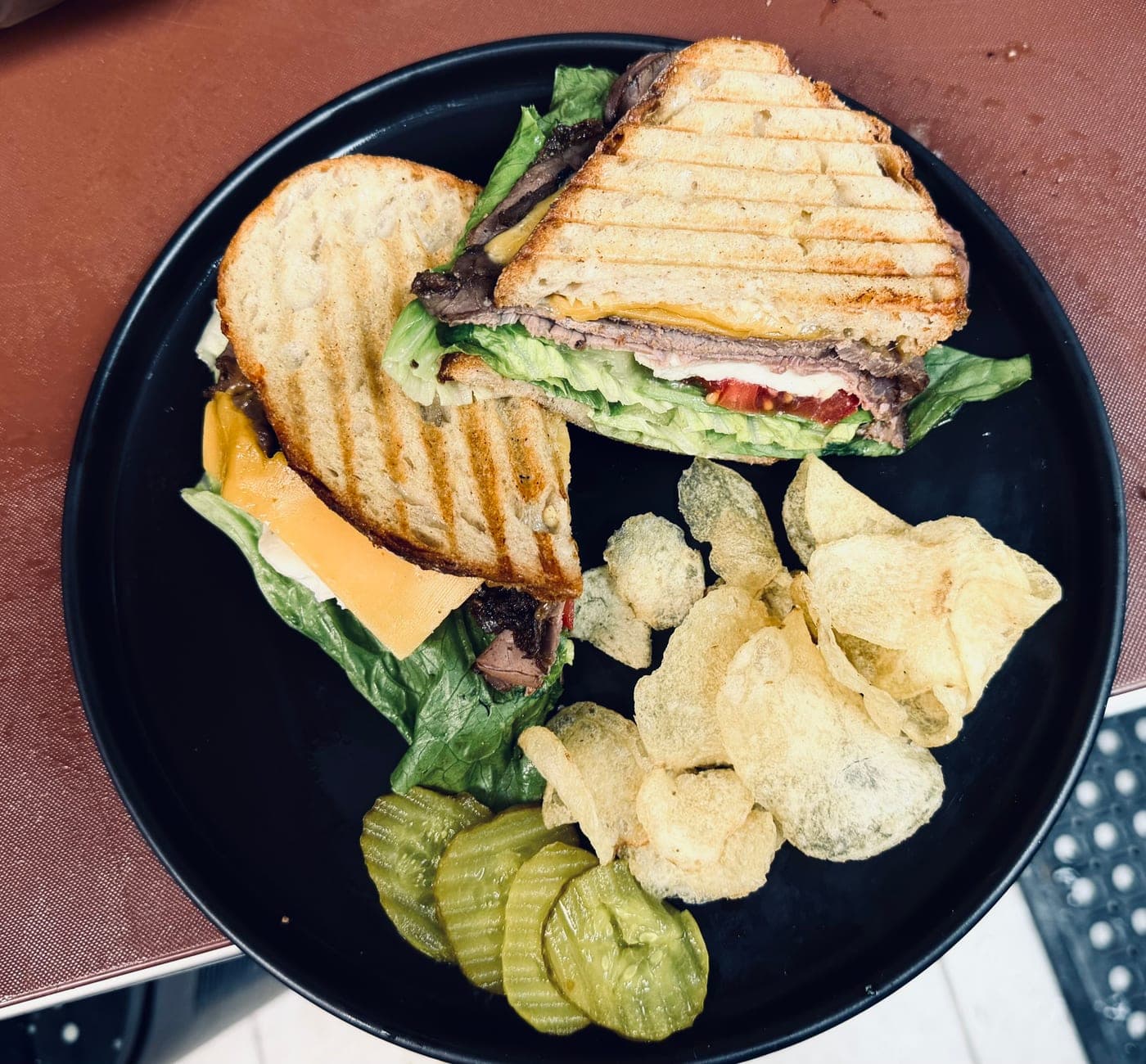 Turkey pesto melt sandwich plate with chips and pickles